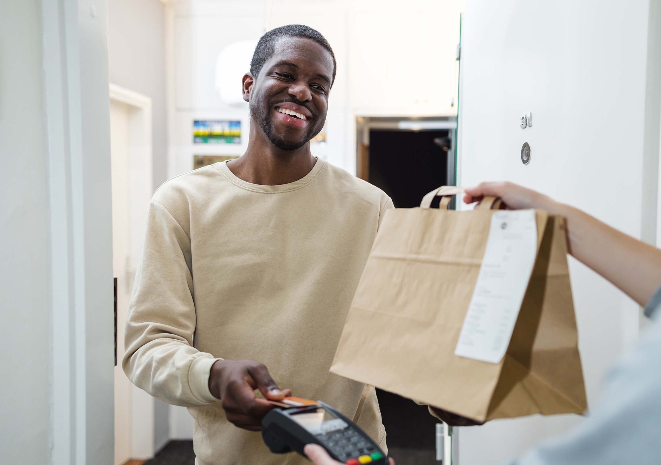 man receiving bag of medication from pharmacy delivery person