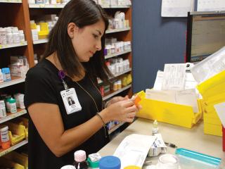 Woman pharmacist filling prescriptions 