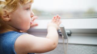 young child trying to open window