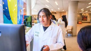 Youth in lab coat working at computer