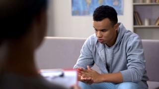 young african american man or boy getting counseling worried