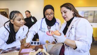 black youth with stethoscopes summit, two students with mentor at youth summit