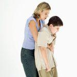 An adult performs the Heimlich maneuver on a choking child, using abdominal thrusts from behind to dislodge the object.