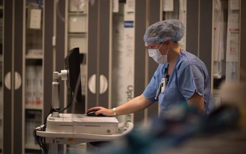 medical professional working at a computer in a clinical setting