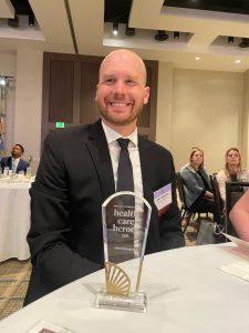 john sylvester sitting at table with his award, sock drive, recognized paramedic, health care hero, first responder award, john sylvester