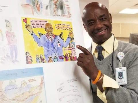 David pointing to a watercolor of himself by anita white