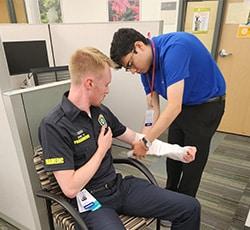 talent garden intern applying brace on ems staff arm, talent garden interns, shadowing, youth of color, youth summits, healthcare mentorship
