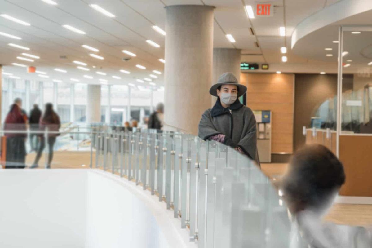 toya standing by a railing in the clinic & specialty center, voices of hennepin healthcare: toya lópez, health professionals for a healthy climate, equitable healthcare, environmental sustainability, community well spaces