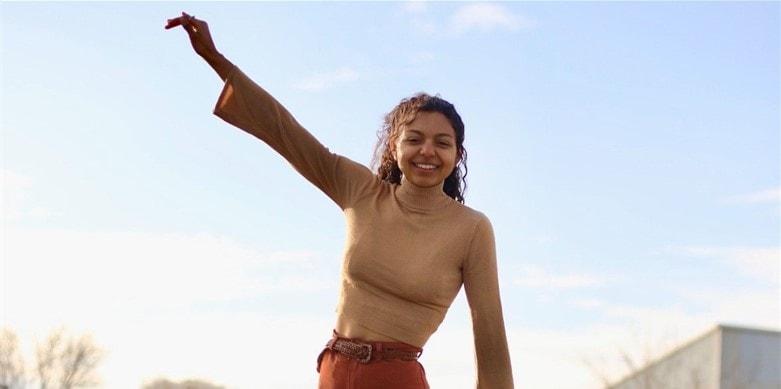 Stella Wright holding up hand and smiling, talent garden, stella wright, talent garden internship program, poetry, black women with stethoscopes, shadowing doctors