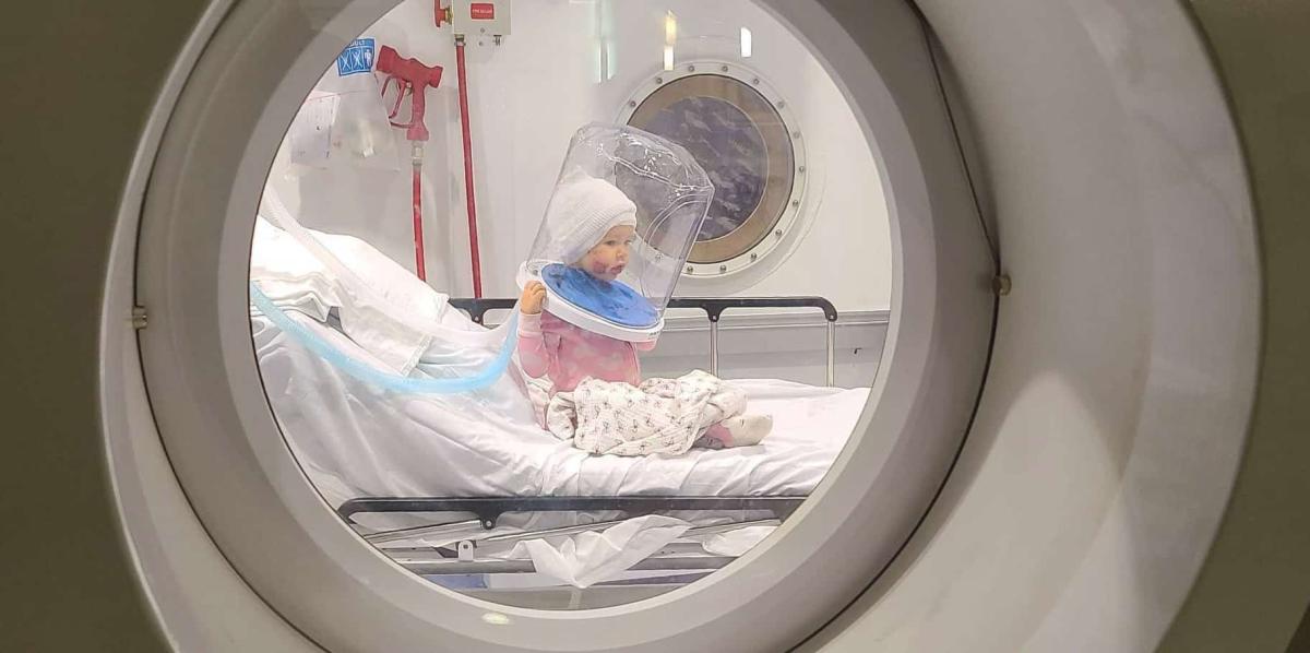 young girl in hyperbaric chamber, dog attack, girl suffers ear amputation, successful hyperbaric treatment, kenzie riemenschneider, facial lacerations from dog attack