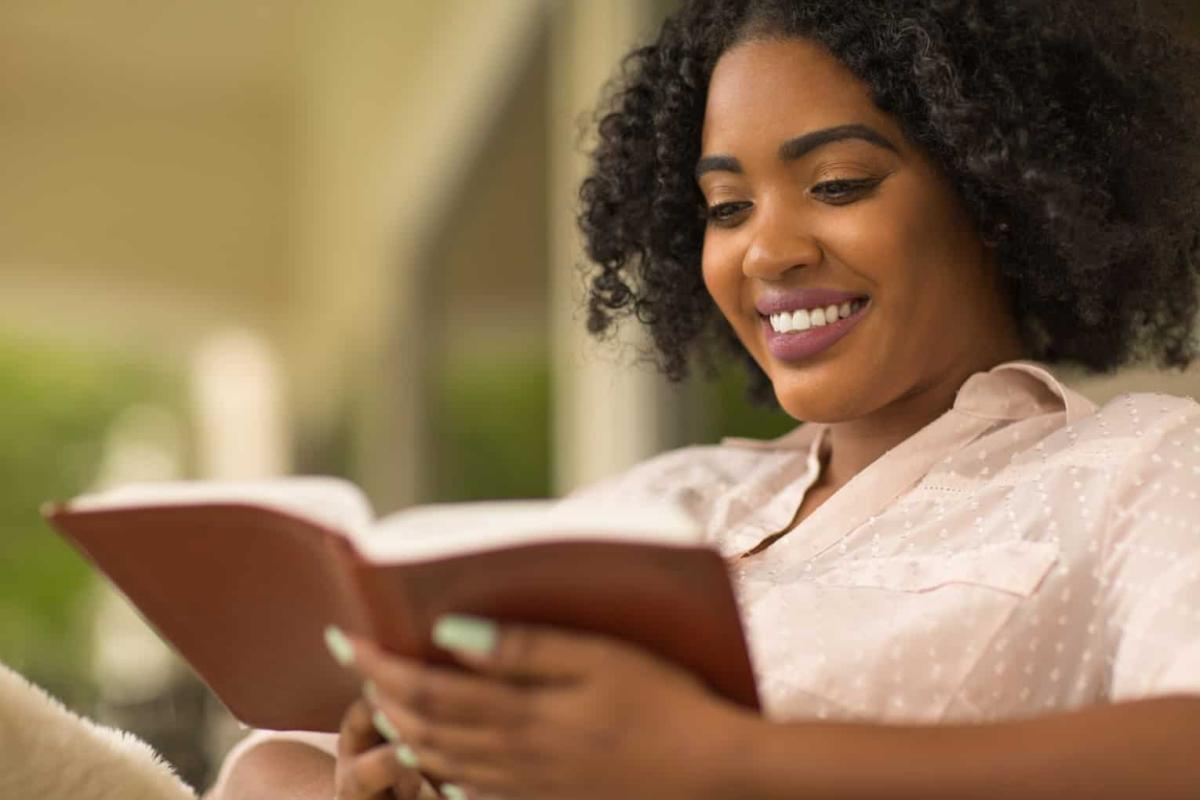 woman smiling and reading a book, find your me time, recognize and reduce your stress, COVID-19 has negatively impacted mental health, practice gratitude, relaxation technique