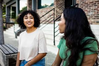 two females outside of a building conversating