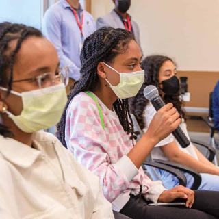 Black Youth with Stethoscopes image of four people, one holding a microphone