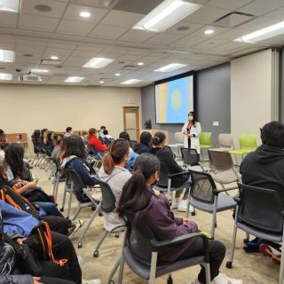 Group of students seated in a classroom listening to a presentation.
