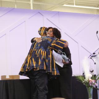 two speakers embracing at the health equity summit